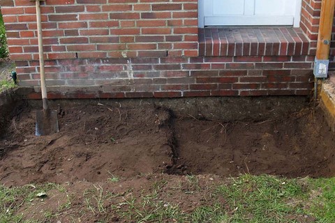 Ich habe die Größe vom geplanten Eingangspodest am Erdboden mit einem Spaten markiert. Dann habe ich Mutterboden bis in eine ausreichende Tiefe abgetragen. Den Mutterboden habe ich in unserem Garten gelagert.