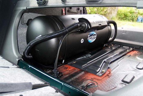 Beim Autogas Umbau eingebauter Gastank im Kofferraum aus Sicht von innen ohne Kofferraummatte