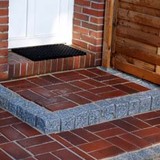 Informationen zum Eingangspodest bauen mit einer Randeinfassung aus Granitpalisaden und einem Belag aus Klinkersteinen. 