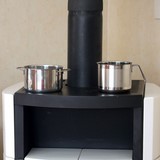 Wassergefüllte Kochtöpfe auf Kaminofen erhöhen Luftfeuchtigkeit